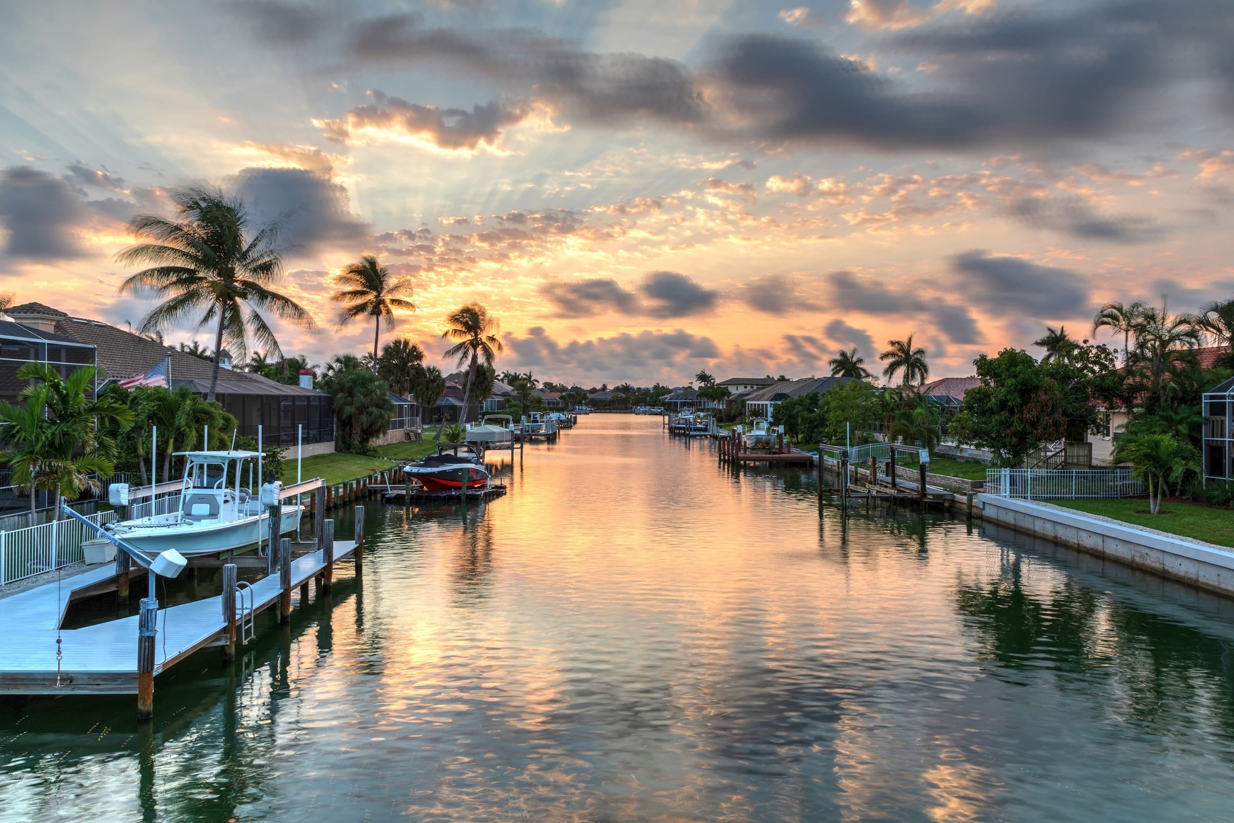 Canal-front homes with private docks at sunset