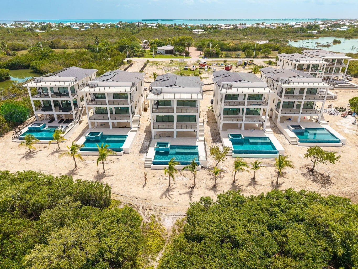 Aerial view of the Seven Palms Cove residences, each with a private pool and spa, palms on the sand and mangroves in front