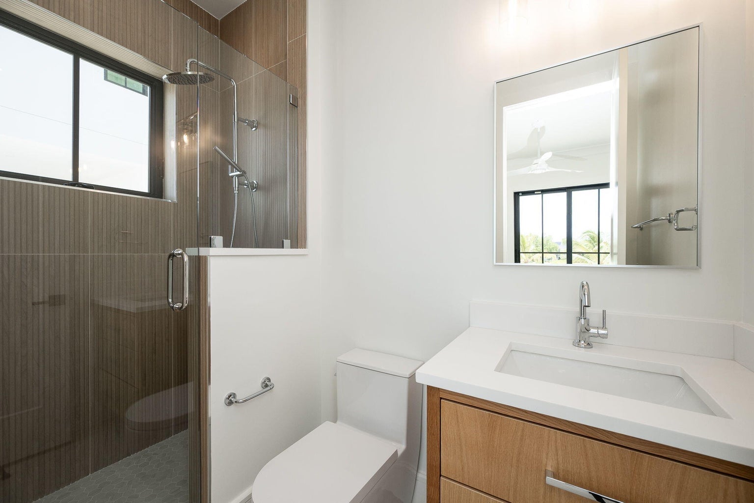 Bathroom with a wood-look tiled glass shower, a framed mirror and a wood vanity