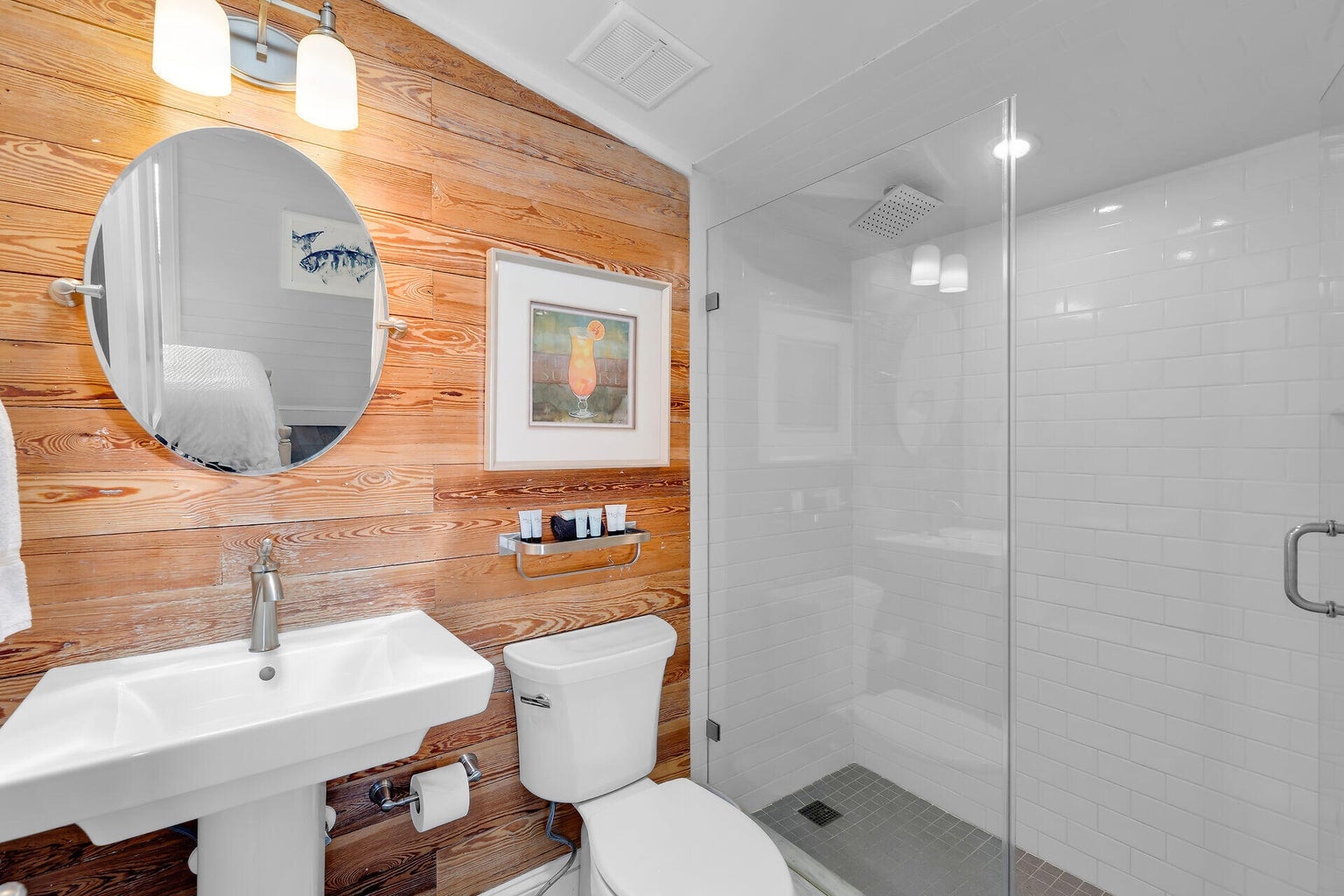 Bathroom with a pine-paneled wall, pedestal sink and a glass-enclosed subway-tile shower