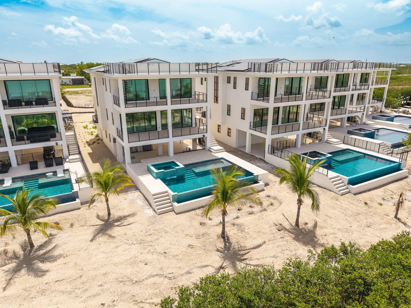 Side-by-side private pools and spas below the glass-railed balconies of the Seven Palms Cove residences